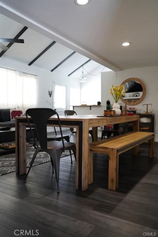 dining area featuring vaulted ceiling with beams and dark hardwood / wood-style flooring