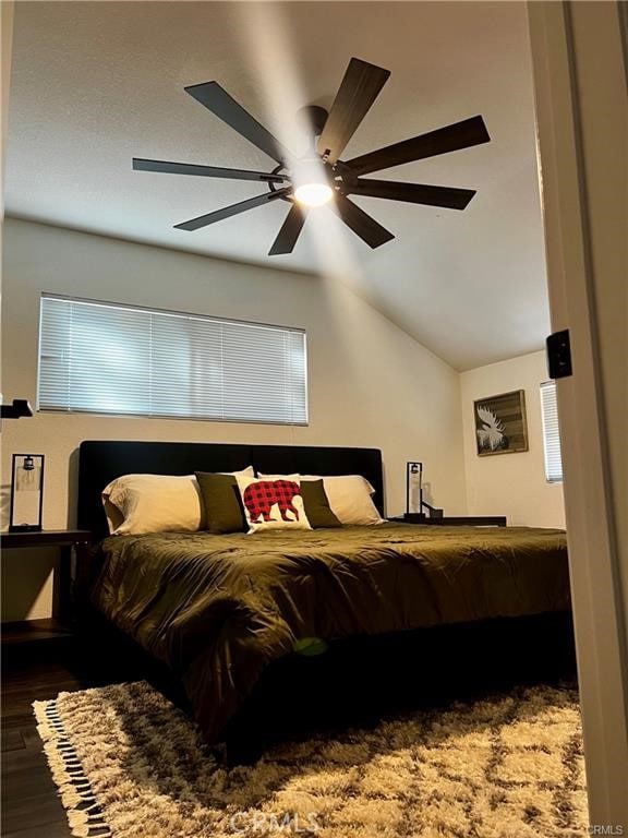 bedroom with vaulted ceiling, dark wood-type flooring, and ceiling fan