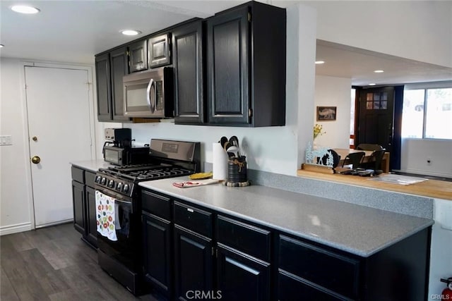 kitchen with black gas range and dark hardwood / wood-style floors