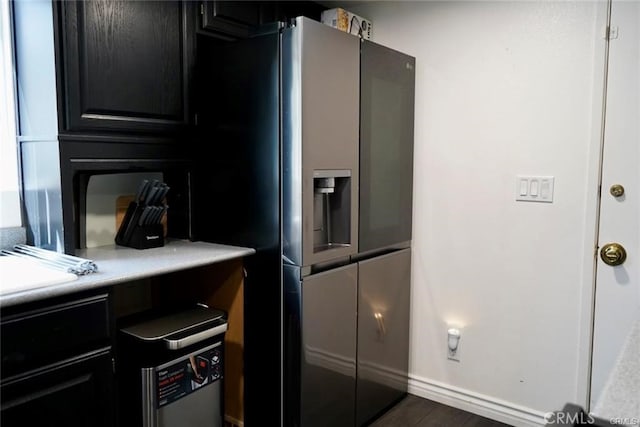 kitchen with stainless steel fridge and dark wood-type flooring