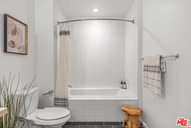 bathroom featuring shower / bath combo with shower curtain, tile patterned flooring, and toilet