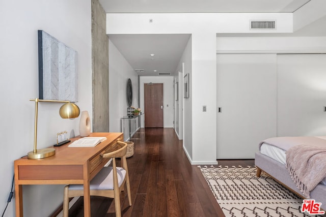 bedroom with dark hardwood / wood-style flooring and a closet