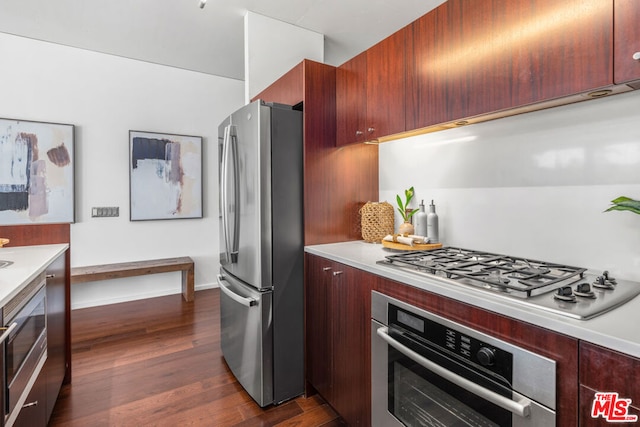 kitchen with appliances with stainless steel finishes and dark hardwood / wood-style floors