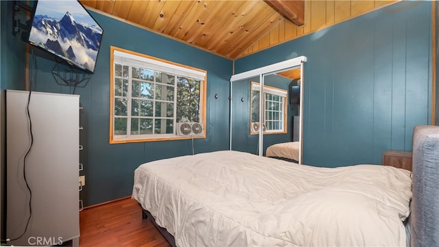 bedroom with vaulted ceiling with beams, a closet, dark wood-type flooring, and wood ceiling