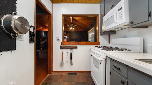 kitchen featuring ceiling fan, white appliances, gray cabinets, tile counters, and vaulted ceiling