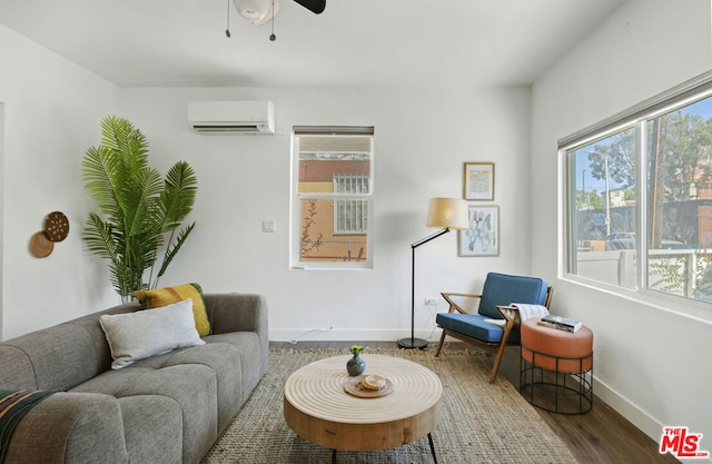 living area with a wall unit AC, ceiling fan, and wood-type flooring