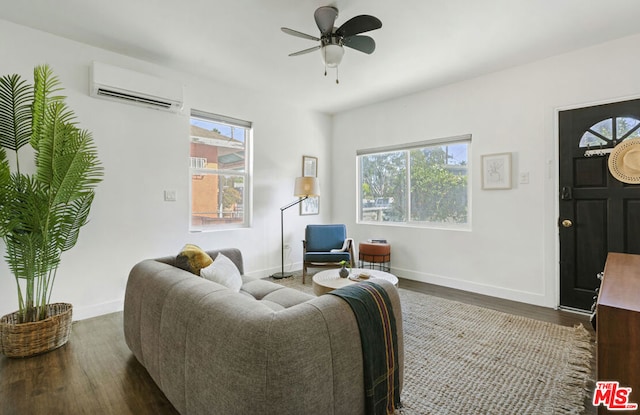 living room featuring a wall unit AC, ceiling fan, plenty of natural light, and dark hardwood / wood-style floors