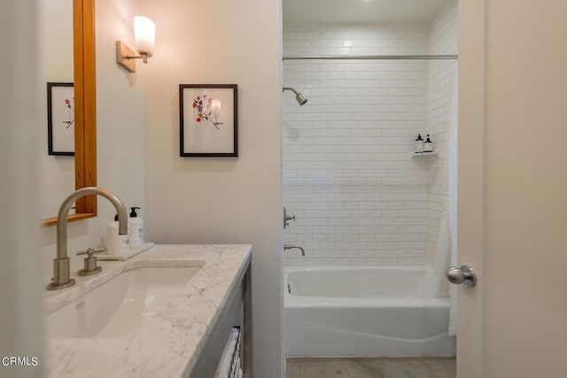 bathroom with tiled shower / bath combo and vanity