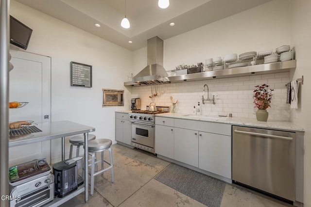 kitchen with sink, hanging light fixtures, appliances with stainless steel finishes, range hood, and white cabinets