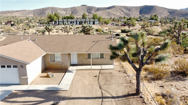 view of front of property with a garage and a mountain view