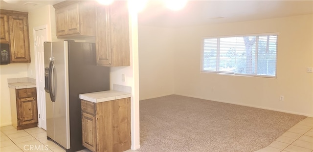 kitchen with stainless steel refrigerator with ice dispenser and light tile patterned flooring