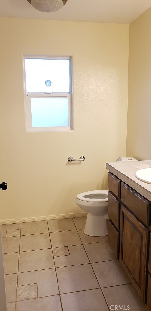 bathroom with tile patterned flooring, vanity, and toilet