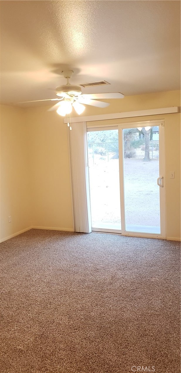 unfurnished room with ceiling fan, a textured ceiling, and carpet