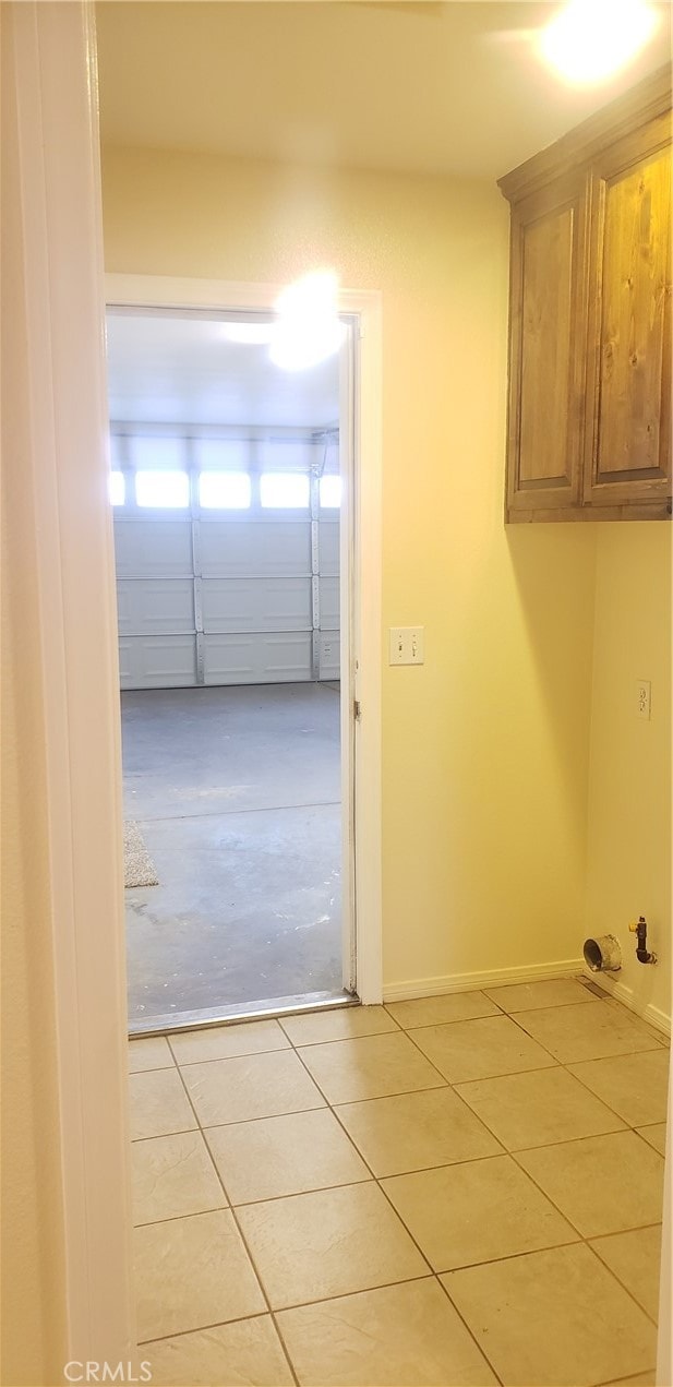 laundry area with light tile patterned flooring