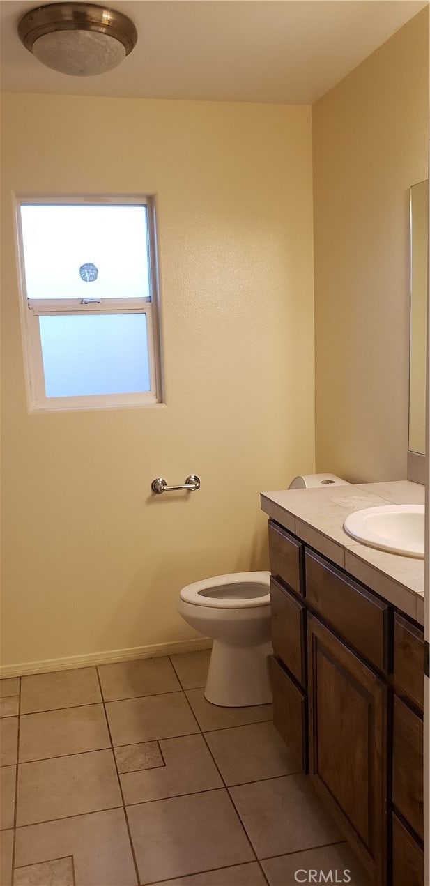 bathroom featuring tile patterned flooring, vanity, and toilet