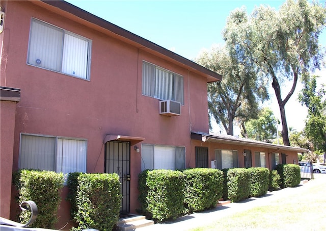 view of side of property with a wall mounted air conditioner