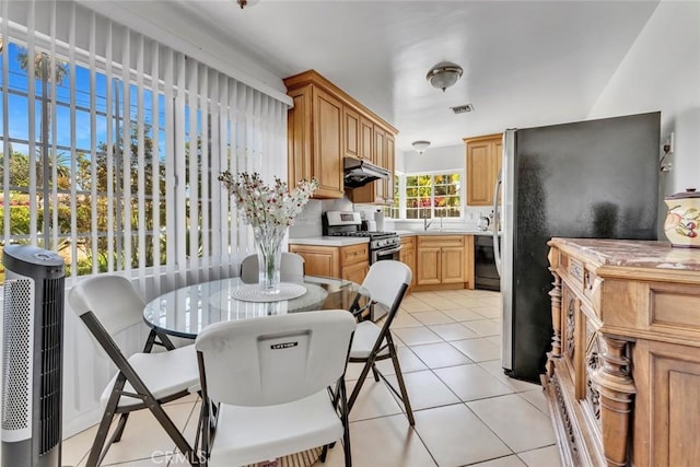1021 S Lark Ellen Ave, West Covina, CA 91791 - kitchen with visible vents, under cabinet range hood, light tile patterned flooring, light countertops, and stainless steel appliances