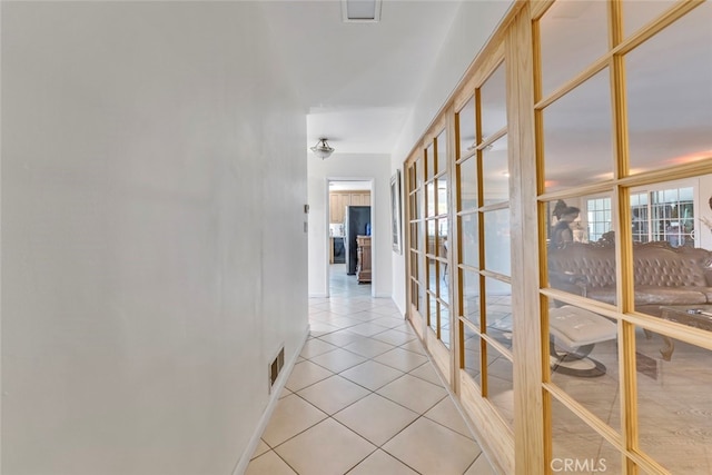 hallway with french doors and light tile patterned floors