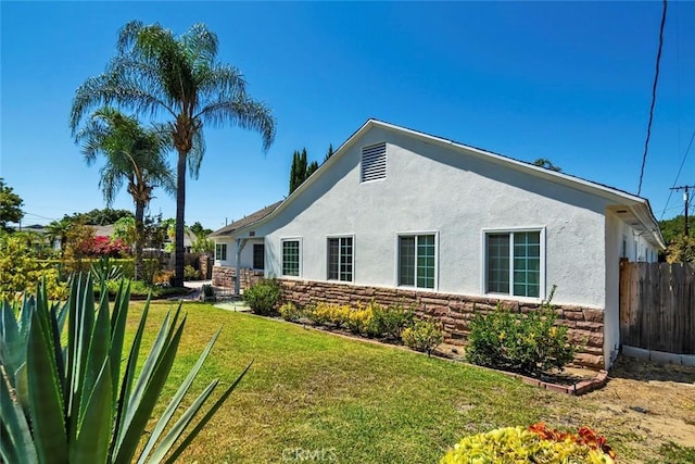 1021 S Lark Ellen Ave, West Covina, CA 91791 - view of property exterior with stucco siding, stone siding, fence, and a lawn