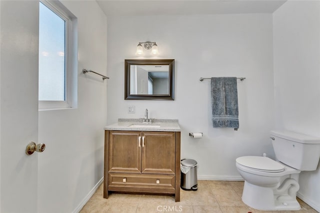 bathroom featuring tile patterned flooring, vanity, toilet, and plenty of natural light