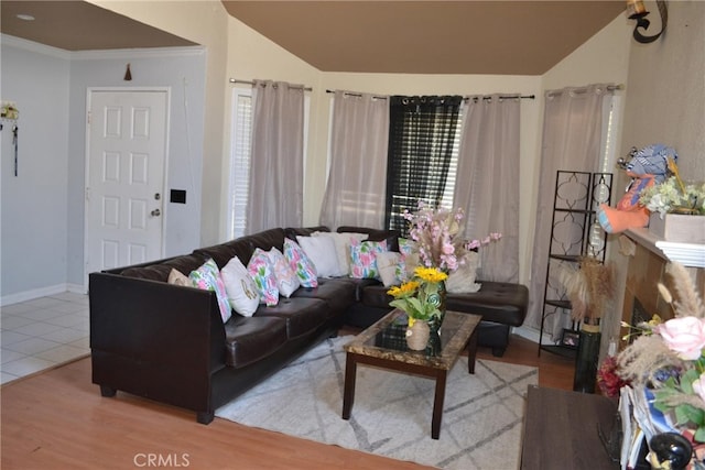 living room featuring light hardwood / wood-style flooring, crown molding, and vaulted ceiling