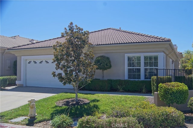 mediterranean / spanish house featuring a garage and a front yard