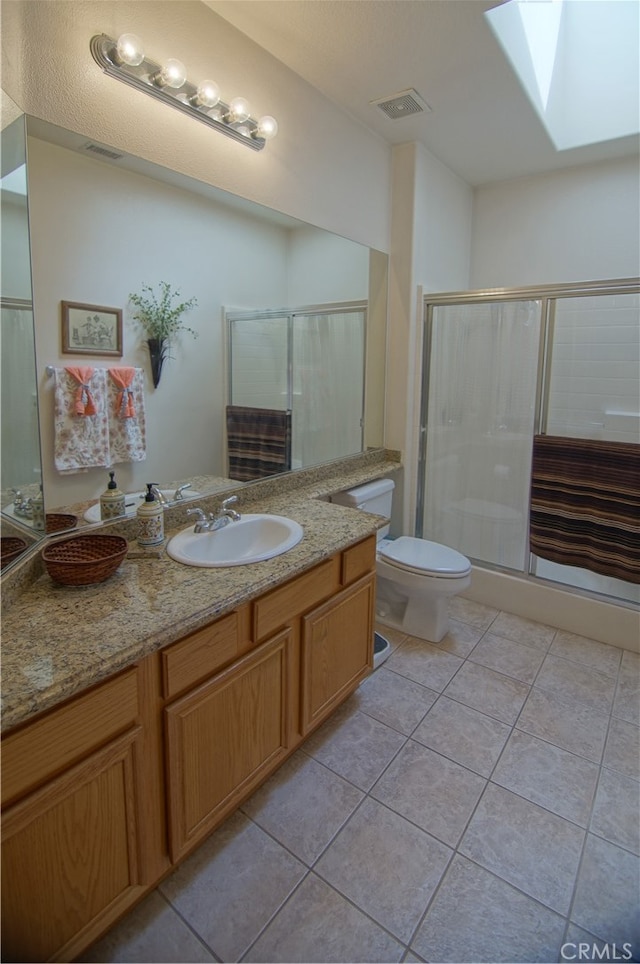 bathroom with a shower with shower door, vanity, and toilet