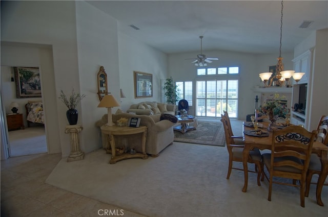 dining space featuring ceiling fan with notable chandelier, vaulted ceiling, and light carpet