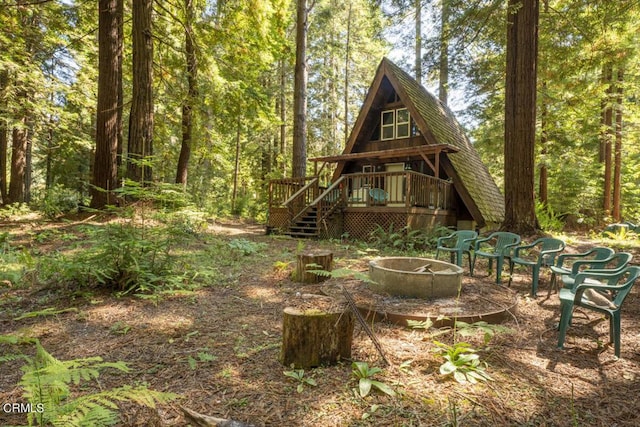 exterior space with a wooden deck and a fire pit