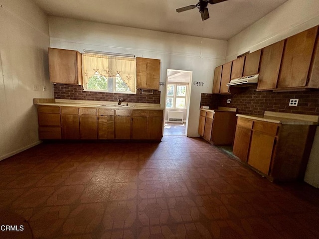 kitchen featuring ceiling fan, sink, and tasteful backsplash