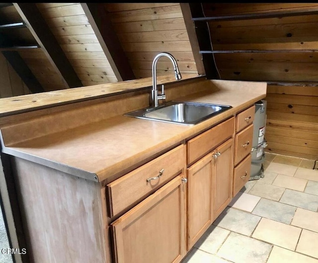 kitchen with wooden ceiling, sink, and wooden walls