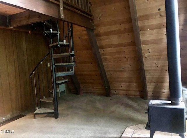 basement featuring a wood stove and wood walls