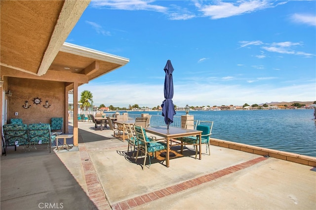 view of patio with a water view and outdoor dining space