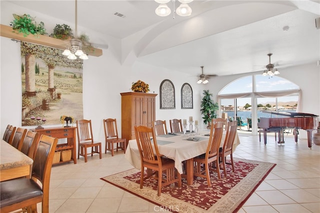 dining space featuring ceiling fan, light tile patterned floors, and a water view