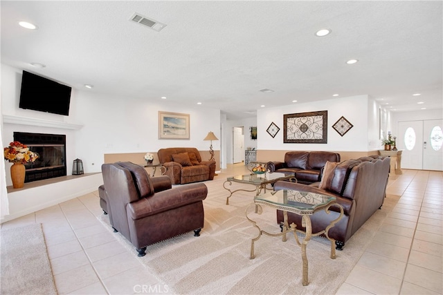 tiled living room featuring a textured ceiling and french doors