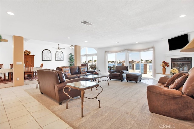 tiled living room featuring ceiling fan and a textured ceiling