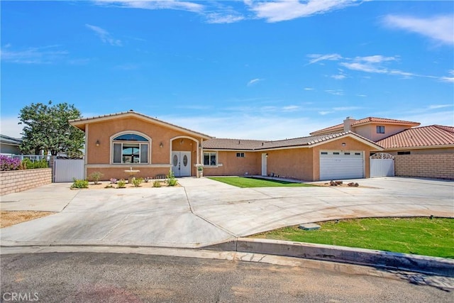 view of front of home with stucco siding, concrete driveway, and fence