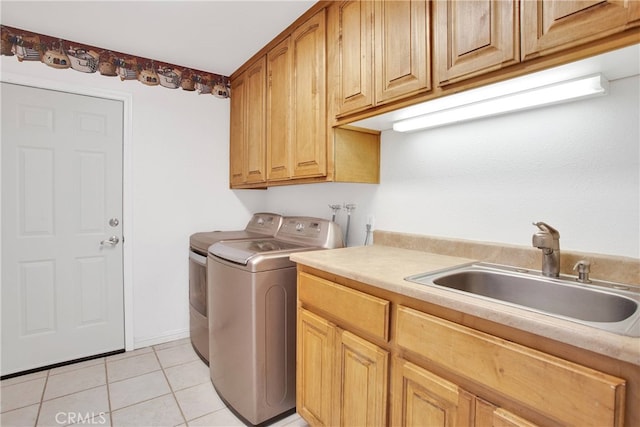 laundry area featuring cabinets, washing machine and dryer, light tile patterned floors, and sink