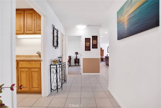 corridor with light tile patterned flooring and sink