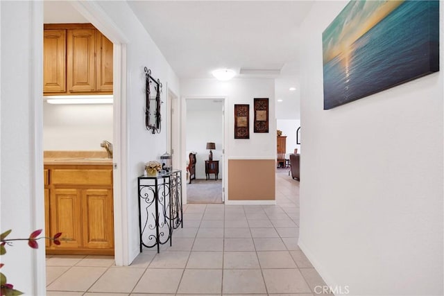 corridor with light tile patterned floors and baseboards