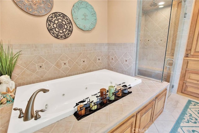 full bathroom featuring tile patterned flooring, a shower stall, and a jetted tub