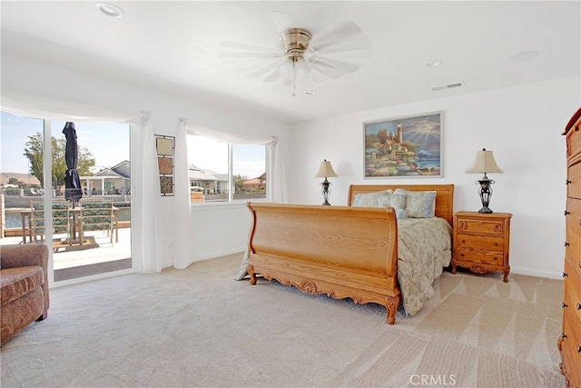 carpeted bedroom featuring access to exterior, visible vents, a ceiling fan, and baseboards