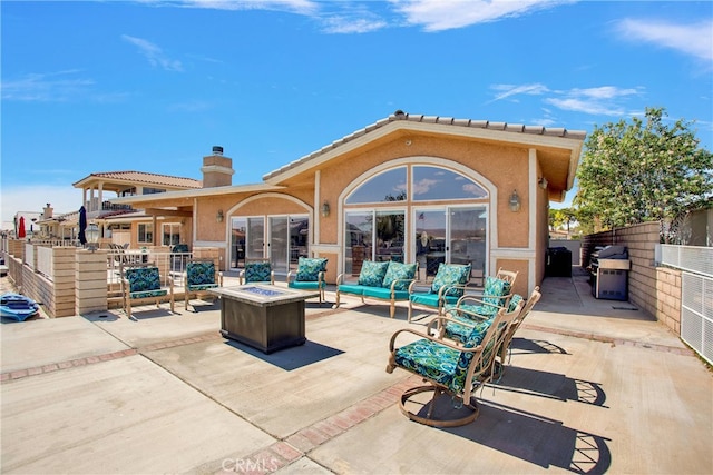 view of patio with grilling area and an outdoor living space with a fire pit