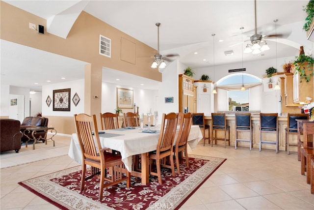 dining area with a high ceiling, ceiling fan, and light tile patterned floors