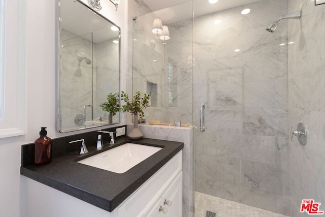 bathroom with vanity and a shower with door