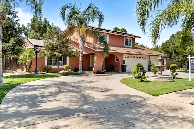 mediterranean / spanish-style house featuring a garage and a front yard