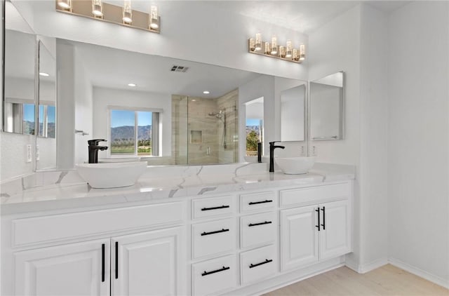 bathroom with hardwood / wood-style floors, vanity, and walk in shower