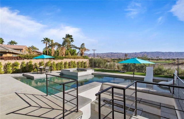 view of swimming pool featuring an in ground hot tub and a mountain view