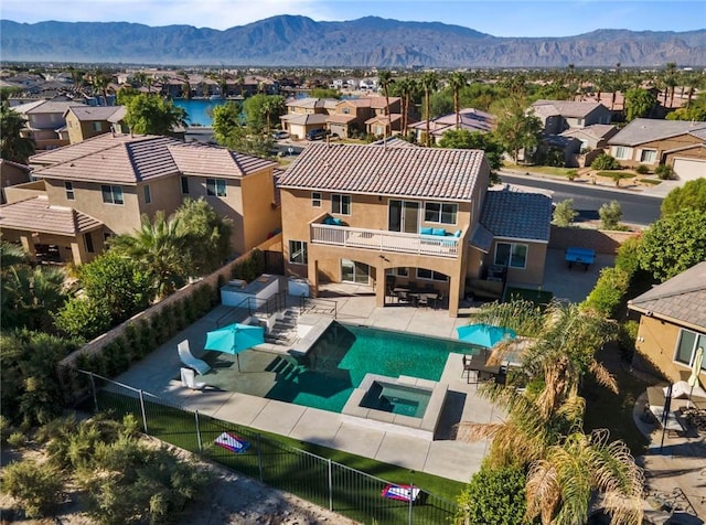 exterior space featuring a mountain view, a patio, and an in ground hot tub