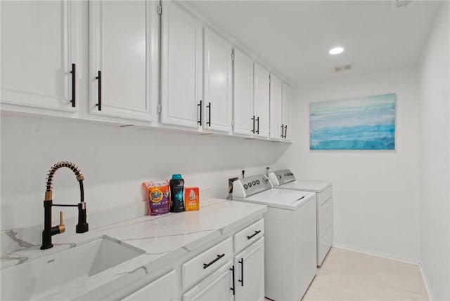 clothes washing area featuring cabinets, independent washer and dryer, and sink